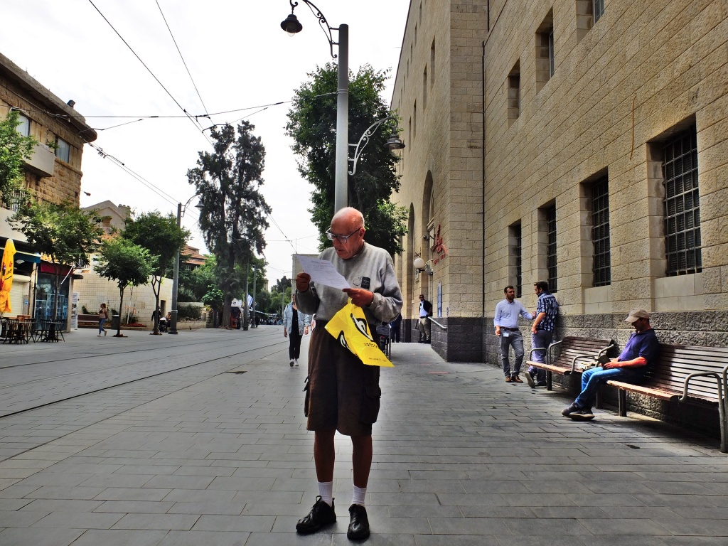 man reading document outside the main post office